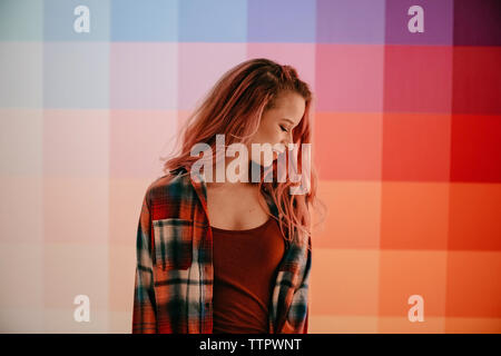 Jeune femme avec des cheveux de l'axe se trouve en face d'ombre wall Banque D'Images