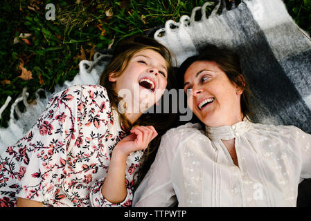 High angle view of mother and daughter lying on picnic blanket at park Banque D'Images