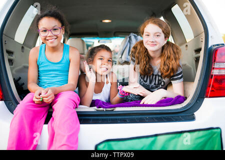 Cheerful friends jouant dans coffre de voiture Banque D'Images