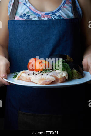 Portrait de femme tenant la viande de poulet avec des légumes dans la plaque Banque D'Images