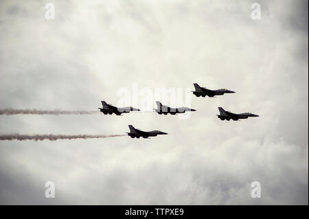 Low angle view of fighter planes dans ciel nuageux au cours de l'aéronautique Banque D'Images