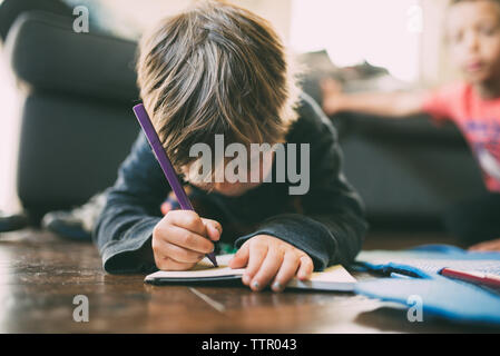 Boy doing homework on à la maison Banque D'Images