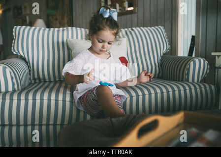 Cute girl Playing with fidget spinner dans la salle de séjour à la maison Banque D'Images