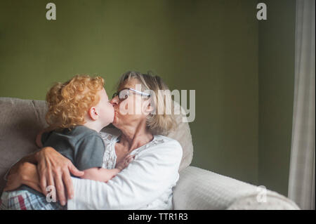 Grand-mère et petit-fils, baiser sur la bouche à la maison Banque D'Images