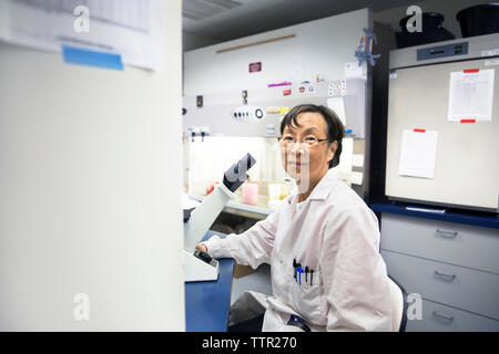 Portrait of senior female scientist using microscope in laboratory Banque D'Images