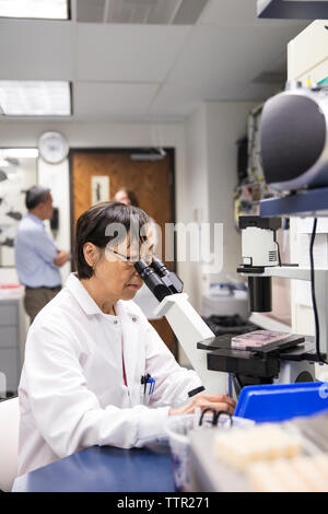 Senior female scientist using microscope in laboratory Banque D'Images