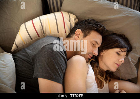 High angle view of couple sleeping on bed Banque D'Images