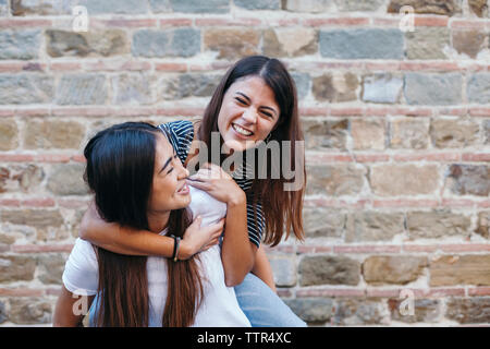 Usurpation de l'heureux ami femme debout par wall Banque D'Images