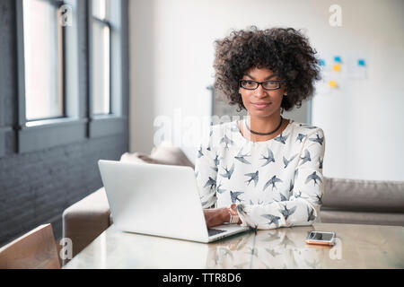 Portrait of businesswoman sitting at desk in office Banque D'Images