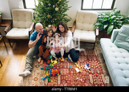 Visioconférence en famille heureuse assis contre le sapin de noël à la maison Banque D'Images