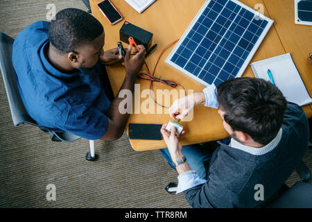 Vue aérienne d'hommes d'affaires travaillant sur panneau solaire en fonction du modèle Banque D'Images