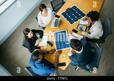 Vue aérienne de gens d'affaires de discuter sur des modèles de panneaux solaires au cours de réunion Banque D'Images