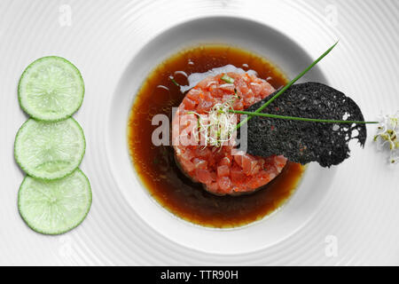 Délicieux poisson rouge avec de la sauce et des tranches de lime on white plate Banque D'Images