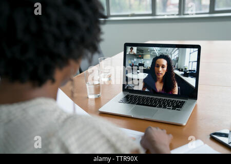 femme d'affaires discutant avec une collègue féminine sur la vidéoconférence dans la salle du conseil Banque D'Images
