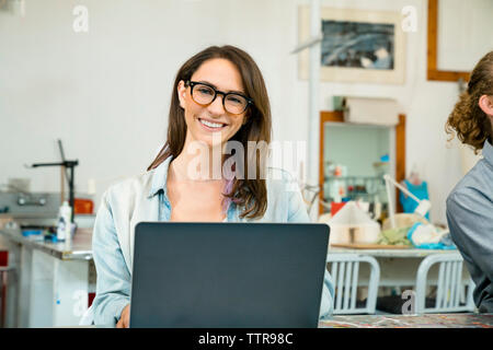 Portrait of happy businesswoman sitting in office par des hommes Banque D'Images