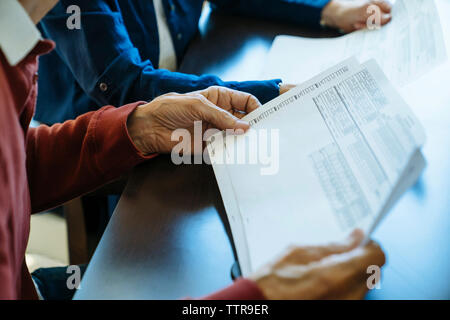 Portrait of senior couple lecture des documents au bureau du conseiller financier Banque D'Images