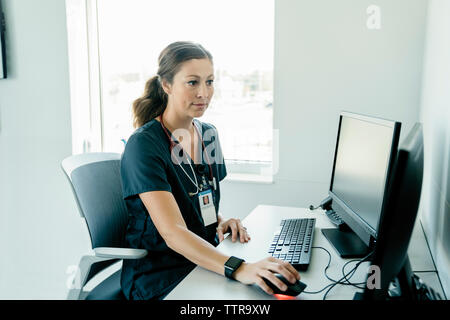 Femme médecin confiant à l'aide d'ordinateur de bureau à l'hôpital Banque D'Images