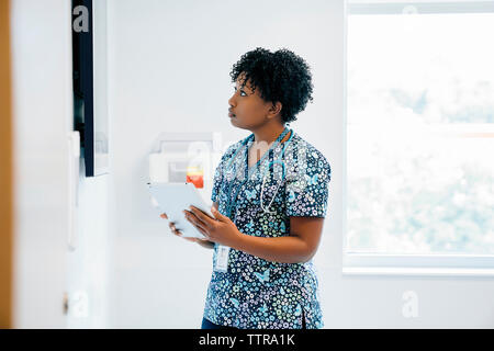 Femme médecin à la télévision à écran ordinateur tablette tout en maintenant à l'hôpital Banque D'Images