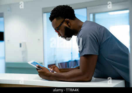 Vue latérale du doctor using tablet computer in hospital Banque D'Images
