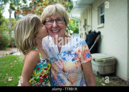 Portrait de grand-mère avec sa petite-fille joyeuse de l'embrasser à la cour Banque D'Images