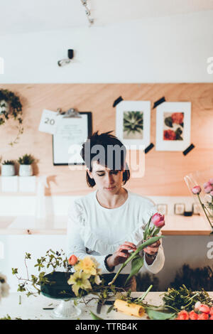 Un fleuriste working at table in flower shop Banque D'Images