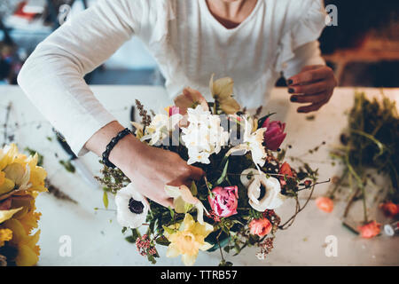 High angle midsection florist arranging flowers at store Banque D'Images