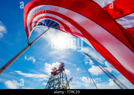 Low angle view of American Flag à derrick contre ciel nuageux Banque D'Images