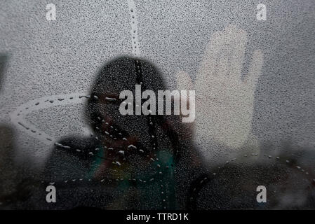 Reflet de la photographie femme main sur verre pendant la mousson humide Banque D'Images