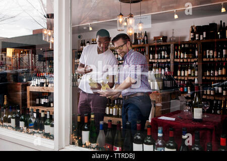 Multi-ethnic colleagues discussing in wine shop Banque D'Images