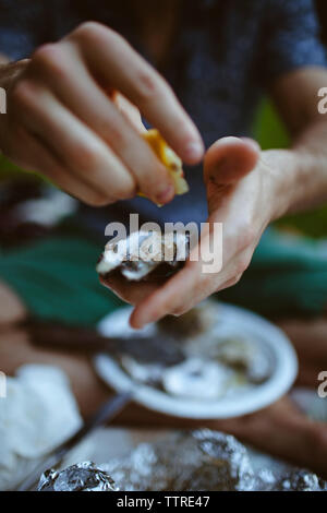 La section basse de l'homme presser le jus de citron frais sur coquille d'huître Banque D'Images