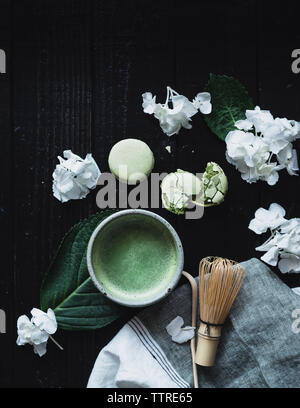 Vue de dessus de thé matcha avec macarons et d'hortensias sur table Banque D'Images