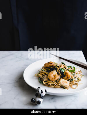 Les nouilles et les crevettes, servi dans la plaque avec panda jouet sur le tableau Banque D'Images