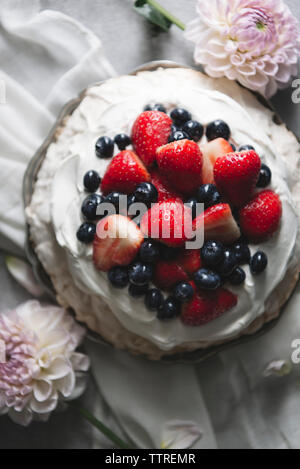 Vue de dessus de pavlova garnie de fruits rouges sur la table Banque D'Images