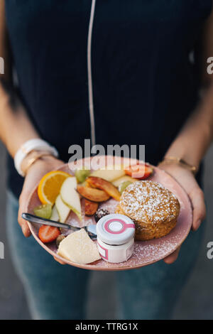 Midsection of woman holding fresh petit-déjeuner dans la plaque au café Banque D'Images