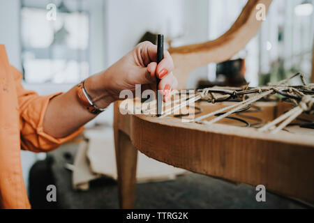 Portrait de femmes faisant de tapissier chaise en bois sur la table dans l'atelier Banque D'Images