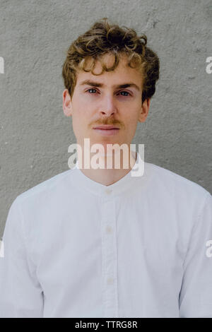 Close-up portrait of man standing contre mur en béton Banque D'Images