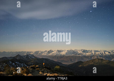 Vue éloignée sur les montagnes du randonneur au milieu de terrain contre star sky Banque D'Images