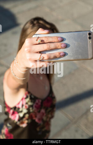 Portrait de femme portant des bijoux en se tenant sur le sentier selfies lors de journée ensoleillée Banque D'Images