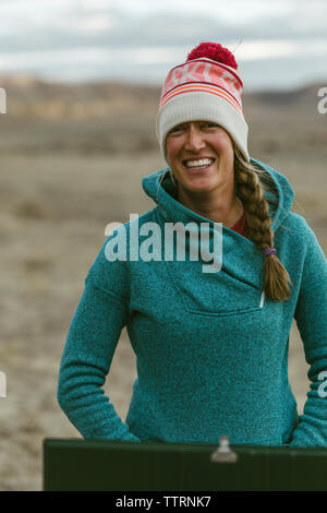 Portrait of smiling woman wearing vêtements chauds tout en se tenant dans le desert Banque D'Images