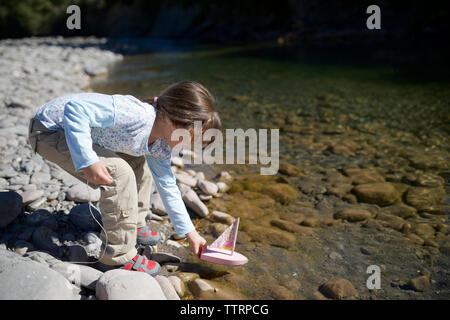 Girl Playing with toy boat au Lakeshore Banque D'Images