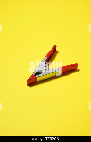 High angle view of clothes peg sur fond jaune Banque D'Images