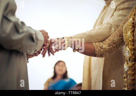 Les doigts de liage prêtre de mariée et le marié pendant la cérémonie du mariage Banque D'Images