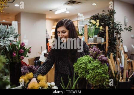 Female florist arranging flowers in store Banque D'Images