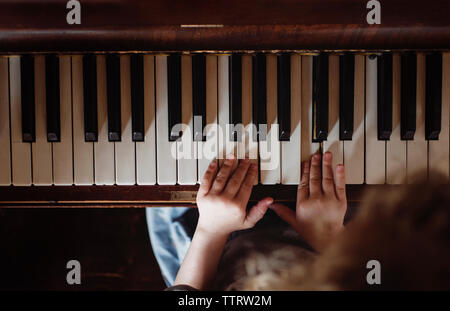 High angle view of girl à jouer du piano à la maison Banque D'Images