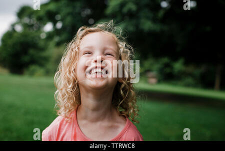 Cute cheerful girl looking at park Banque D'Images