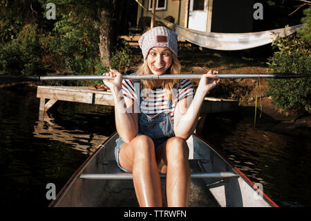 Portrait of woman holding oar tout en faisant face en bateau sur la rivière au Parc Provincial Algonquin Banque D'Images