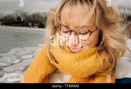 Portrait de femme blonde avec des lunettes tout en souriant à la plage Banque D'Images