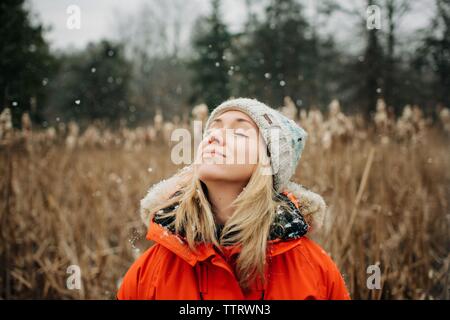 Femme debout dans la neige avec sa tête en profitant de l'air frais à l'extérieur Banque D'Images