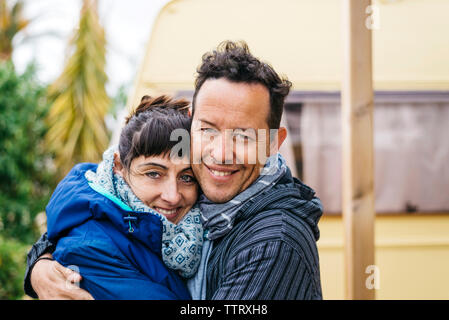 Portrait of happy young couple hugging and smiling outdoors Banque D'Images