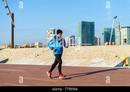 Toute la longueur de senior man jogging tout en exerçant au parc en hiver Banque D'Images